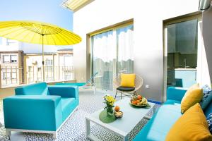 a living room with blue furniture and a yellow umbrella at Graffiti Suites Málaga in Málaga