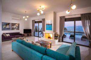 a living room with a blue couch and a fireplace at Villa Bellelen in Agios Nikolaos
