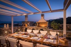 a dinner table on a patio with a fireplace at Villa Bellelen in Agios Nikolaos