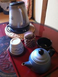 a tea pot and plates on a table with a coffee maker at Rakucho Ryokan in Kyoto