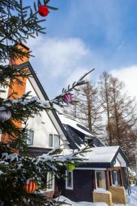a house with a christmas tree in front of it at White Rose Inn in Hachimantai