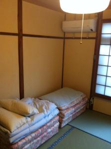 a room with two beds in the corner of a room at Rakucho Ryokan in Kyoto