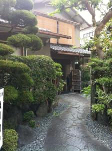 een Japanse tuin met een wandelpad voor een gebouw bij Rakucho Ryokan in Kyoto