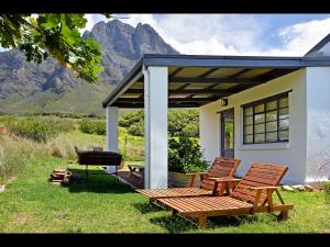 
a wooden bench sitting in front of a house at Boschendal Farm Estate in Franschhoek

