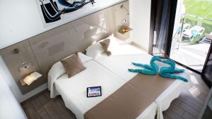 a small room with a white bed in a room at FBC Fortuny Resort - Adults Only in Maspalomas