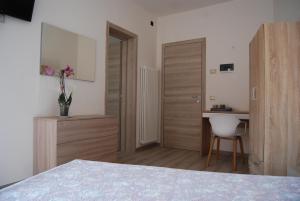 una camera da letto con un letto, una scrivania e una sedia di CORTE GRAZIA a San Zeno di Montagna