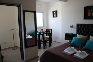 - une chambre avec un lit, un miroir et une table dans l'établissement Villa Cabrera Apart and Suites, à Córdoba