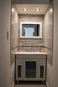 uma casa de banho com um lavatório e um espelho em Villa Cabrera Apart and Suites em Córdova
