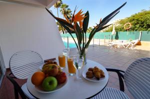プエルトリコにあるApartamentos Miami Gran Canariaのフルーツ2皿とオレンジジュースのグラスを用意したテーブル