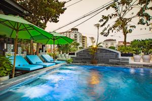una piscina con sillas azules y sombrilla en Truc Loc Villa en Hoi An