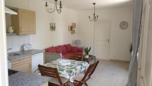 cocina y sala de estar con mesa y sofá rojo en Coté Marais en Chaillé-les-Marais