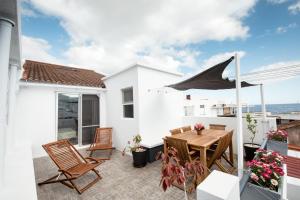 a patio with a wooden table and chairs at Vista do Cais in Lagoa