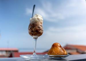 a glass of ice cream and a pear on a table at Marranzanu Rooms in Santa Teresa di Riva