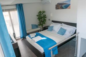 a small bedroom with a bed with blue accents at B&B Marranzanu in Santa Teresa di Riva