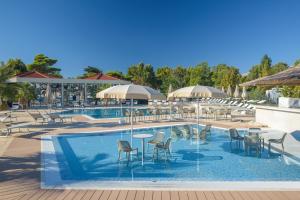 - une piscine avec des chaises, des tables et des parasols dans l'établissement Camping Stobreč Split, à Split