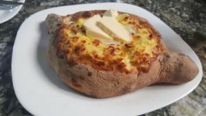 a small pizza on a white plate on a table at Guest house Romanadze in Kobuleti