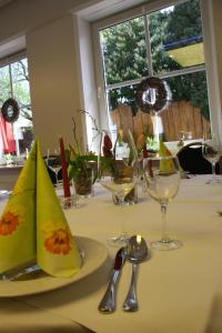 a table with glasses and a plate with napkins on it at Alte - Post - Hotel in Schöppingen