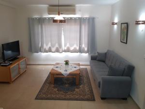 a living room with a couch and a table and a tv at Bertha's Coffee in Afula