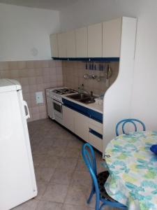 eine Küche mit einem Tisch, einer Spüle und einem Herd in der Unterkunft Suzana Apartment in Novi Vinodolski