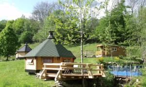 una cabaña de madera en un campo con una casa en Le Domaine du Châtelet, en Ferdrupt