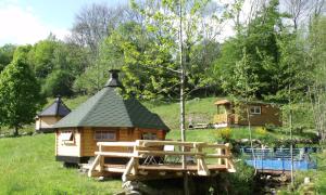 a log cabin in a field with a house at Le Domaine du Châtelet in Ferdrupt