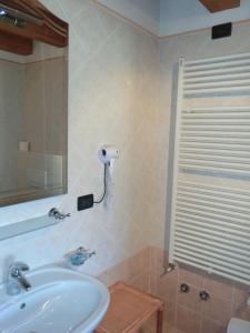 a bathroom with a sink and a phone on the wall at Agriturismo Domus Rustica in Cormòns