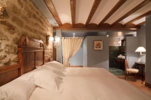 um quarto com uma cama e uma parede de pedra em Hospederia de los Parajes em Laguardia