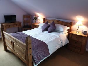 a bedroom with a large bed and a television at Kirk Cottage in Tobermory