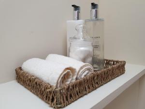 a basket with towels and a bottle of soap on a shelf at Kirk Cottage in Tobermory