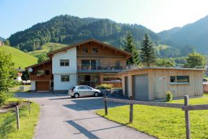une maison avec une voiture garée devant dans l'établissement Haus Diedams, à Schoppernau