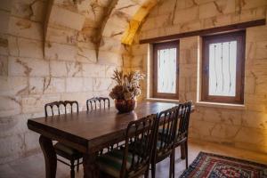 a dining room with a wooden table and chairs at Kayakapi Premium Caves Cappadocia in Ürgüp