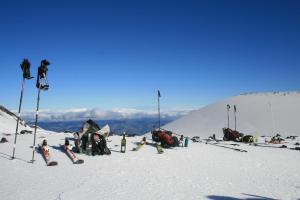 a group of people sitting on a snow covered mountain at Rifugio Il Ginepro dell'Etna in Linguaglossa