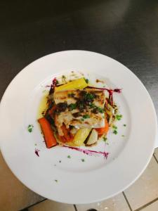 a white plate of food on a table at Hôtel Le Porquerollais in Porquerolles