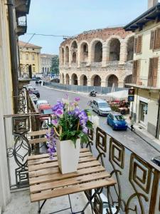 eine Bank auf einem Balkon mit Blick auf das Kolosseum in der Unterkunft Truly Verona in Verona