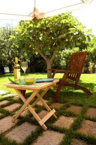 a picnic table with a bottle of wine and a chair at Locanda Delle Mura Anna De Croy in Magliano in Toscana
