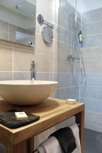 La salle de bains est pourvue d'un lavabo et d'une douche. dans l'établissement LOGIS HOTEL - Auberge de l'Hélix, à Rosoy