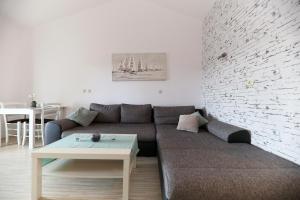 a living room with a couch and a brick wall at Villa Mičić in Zadar