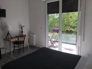 een slaapkamer met een bed, een bureau en een raam bij Four Rooms in Bologna