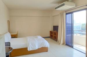 a bedroom with a bed and a large window at Grand Residence Ngamwongwan 19 in Nonthaburi