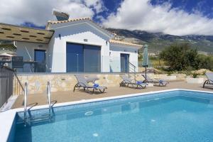 a villa with a swimming pool in front of a house at Vista Blu Villa in Vlachata