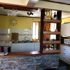 a kitchen with white cabinets and a brick wall at Casa de Campo Reina Margarita in Santa Cruz +12 photos