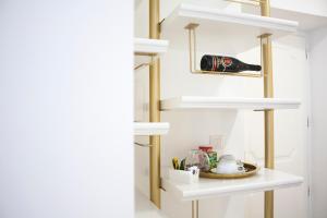 Una cocina con estantes blancos y una botella de vino. en CiuriTaormina Maison de Charme, en Taormina