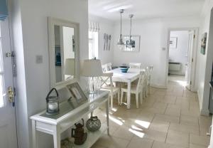 a white dining room with a white table and chairs at Sea Lodge Holiday Home in Bantry