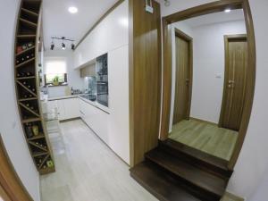 um corredor com uma escada que conduz a uma cozinha e um espelho em Apartmani Jela Zlatar em Vukovina
