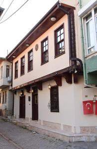 a building with black doors and windows on a street at ÖZ Butik Otel Antik Kent Myrleia in Mudanya