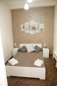 sypialnia z białym łóżkiem i 2 szafkami nocnymi w obiekcie Antico Mercato w Katanii