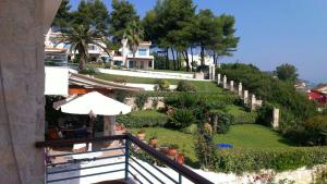 balkon z widokiem na ogród i dom w obiekcie Joanna's Seaside Villa w mieście Kallithea