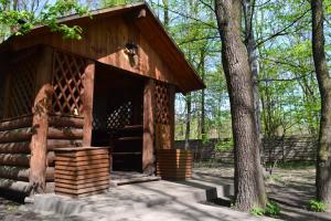 a log cabin in the woods with a tree at Bumerang Hotel in Lviv
