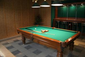 a pool table with two cuesticks in a room at Bumerang Hotel in Lviv