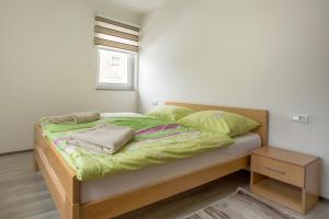1 cama con sábanas y almohadas verdes en una habitación en Ivana, en Tomislavgrad